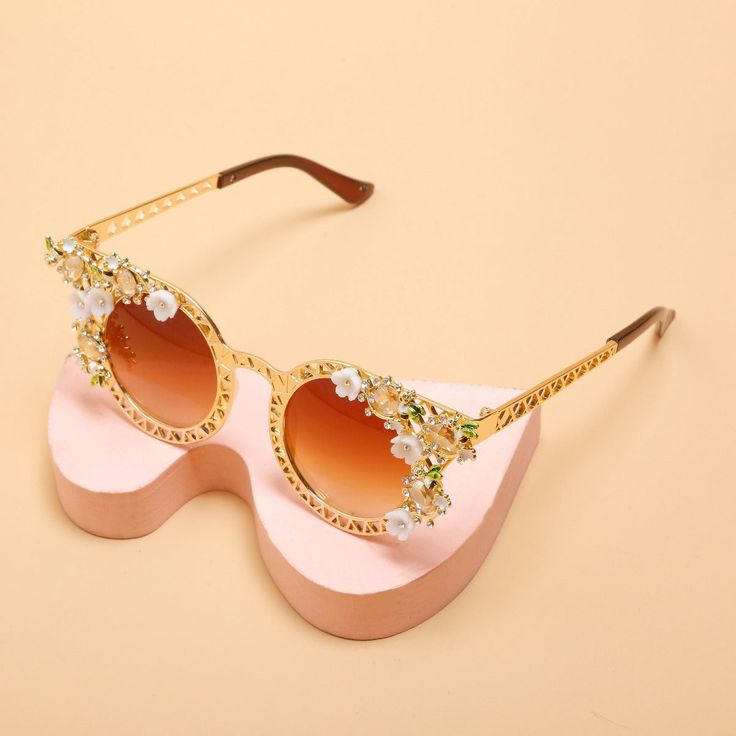 Gorgeous Flower Cat Eye Sunglasses inspired by Vintage European Fashion with a delicate floral design adorned with crystals. Style: Cat EyeDepartment Name: AdultFrame Material: RESINEyewear Type: SunglassesLens Height: 5.3CMLenses Material: Plastic Feminine Tinted Sunglasses For Spring, Elegant Mirrored Sunglasses For Spring, Glamorous Gold Sunglasses For Summer, Chic Glass Cat Eye Sunglasses For Spring, Elegant Sunglasses With Gradient Lenses For Spring, Elegant Spring Sunglasses With Gradient Lenses, Elegant Gold Sunglasses For Spring, Elegant Gold Sunglasses, Elegant Beach Sunglasses For Spring