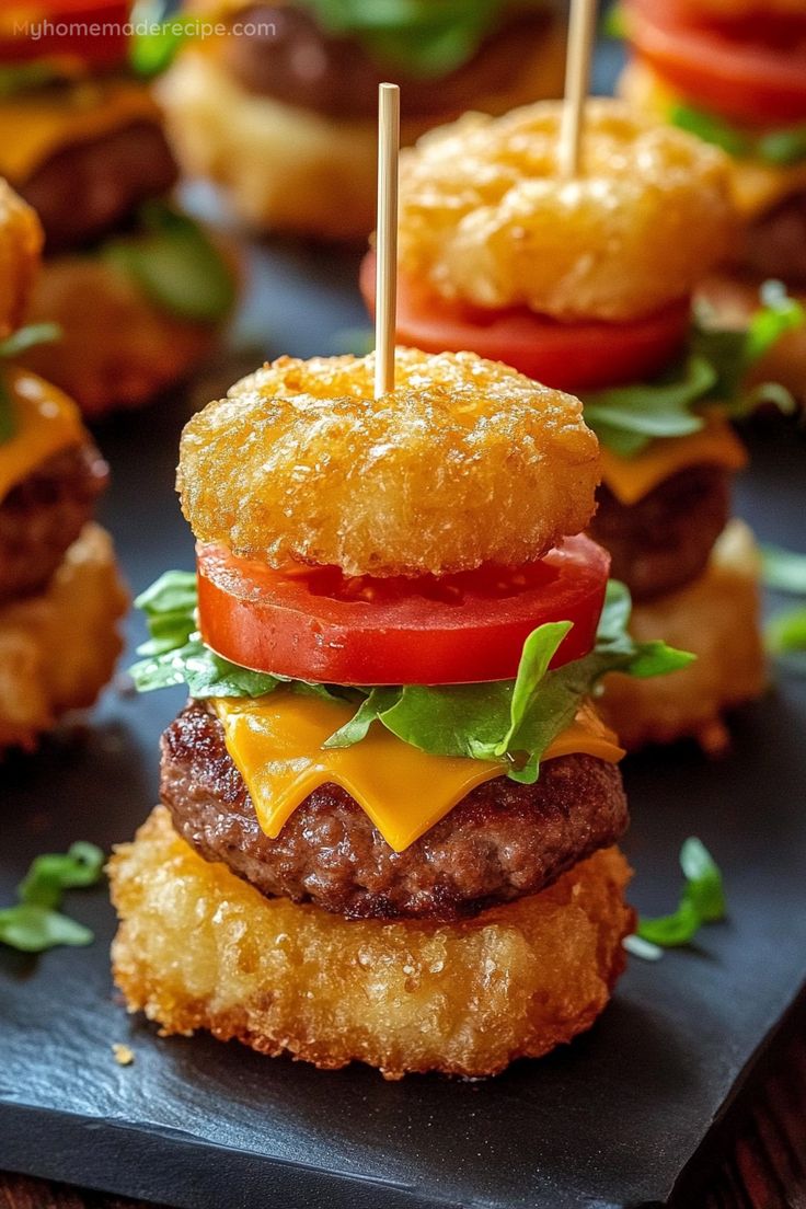 mini hamburgers with cheese and tomatoes on them