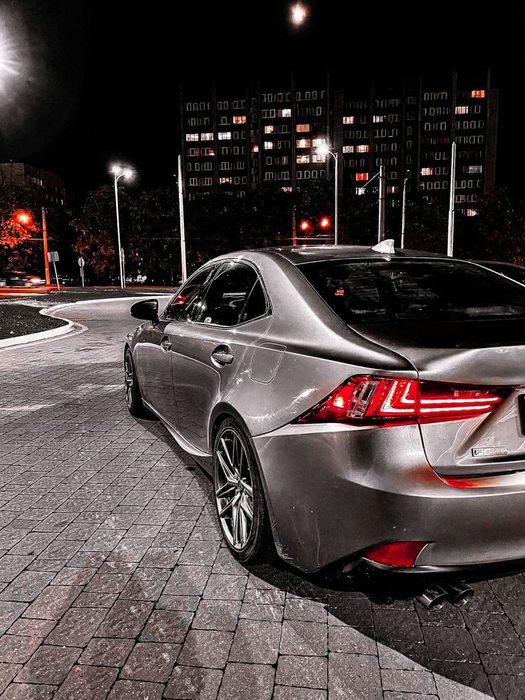 a silver car parked on the street at night