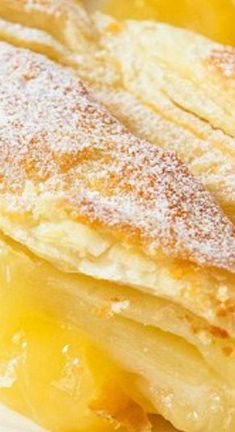 a close up of some food on a plate with powdered sugar and fruit in the background