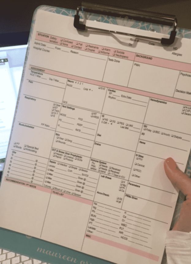 a person holding a clipboard in front of a computer