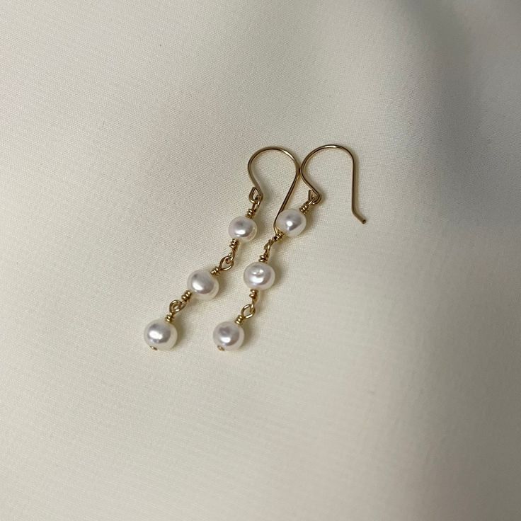 A subtle way to elevate any look. 3 5mm freshwater pearls wrapped with gold fill or sterling silver wire. 3.5cm in length Pearl Drop Earrings Gold, Pearl Drop Earrings, Pearl Drop, Microfiber Cloth, Silver Wire, Favorite Jewelry, Freshwater Pearls, Gold Filled, Drop Earrings