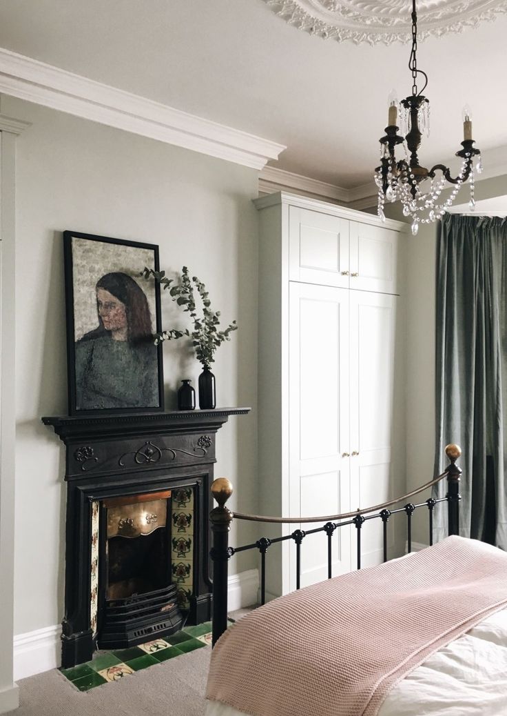 a bedroom with a bed, chandelier and fireplace