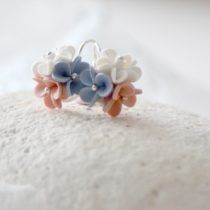 a ring with flowers on it sitting on top of a white cloth covered tablecloth