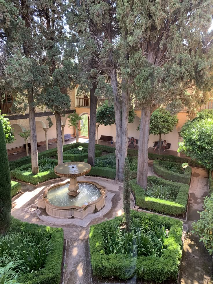 an outdoor garden with fountain surrounded by trees