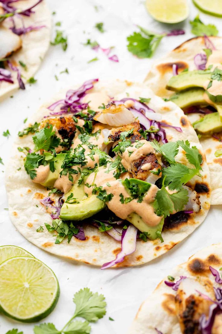 three tortillas with chicken, avocado and cilantro on top