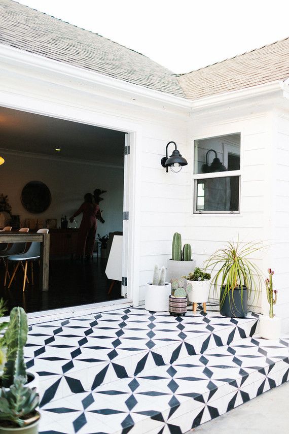 an image of a patio that is decorated with black and white geometric tiles on the ground