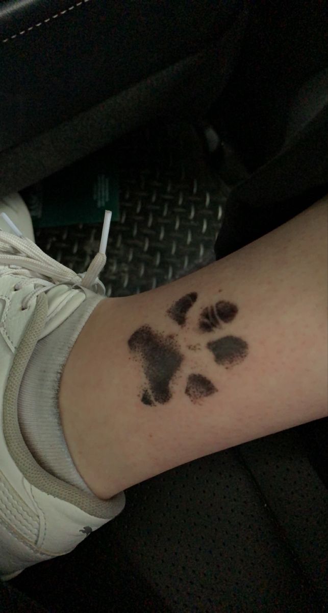 a person with a tattoo on their arm that has a dog paw print on it