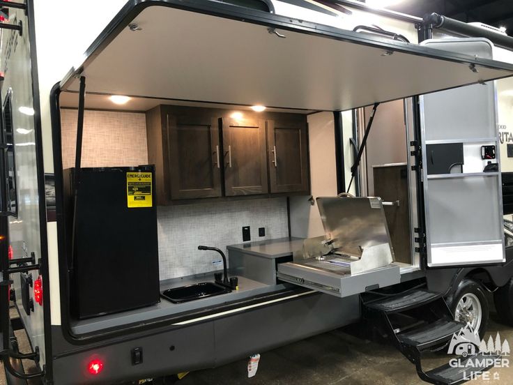 an rv with its door open and the kitchen area in place to be used for cooking