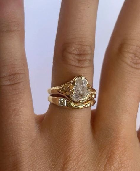 a woman's hand with a yellow gold ring on it and a diamond in the middle