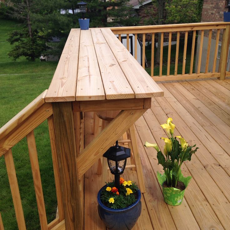 a potted plant sitting on top of a wooden deck next to a lamp post