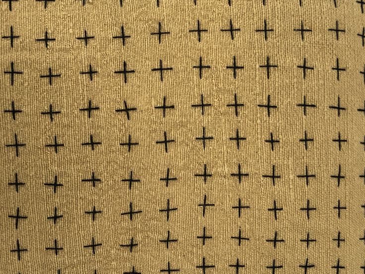 the fabric has crosses on it in black and tan colors, as well as an off - white background