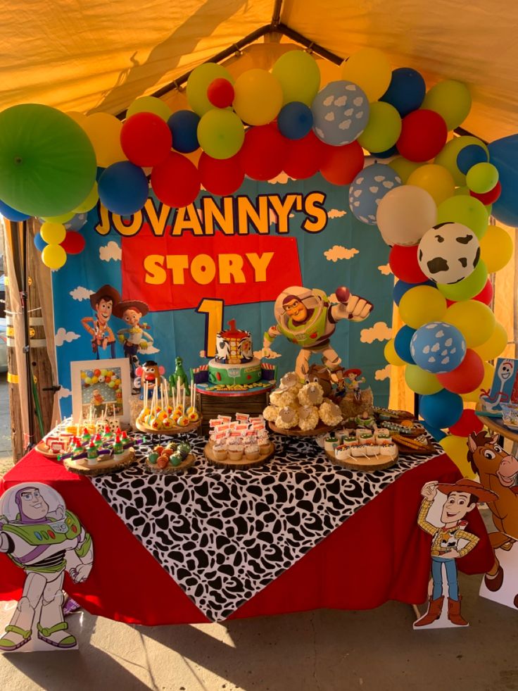 there is a birthday party with balloons and toys on the table in front of it