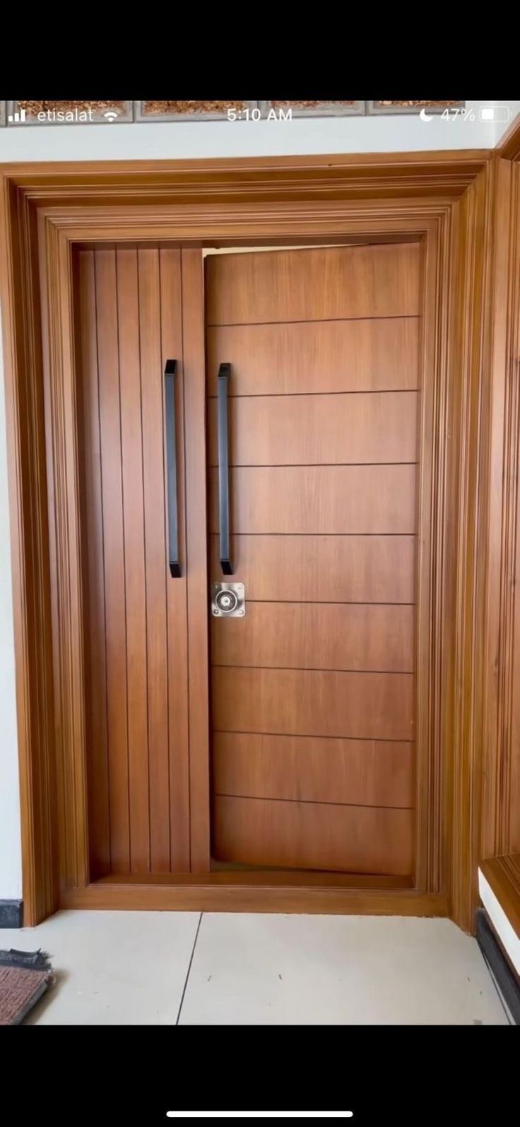 a wooden door with two black handles on the front and side doors that are made out of wood