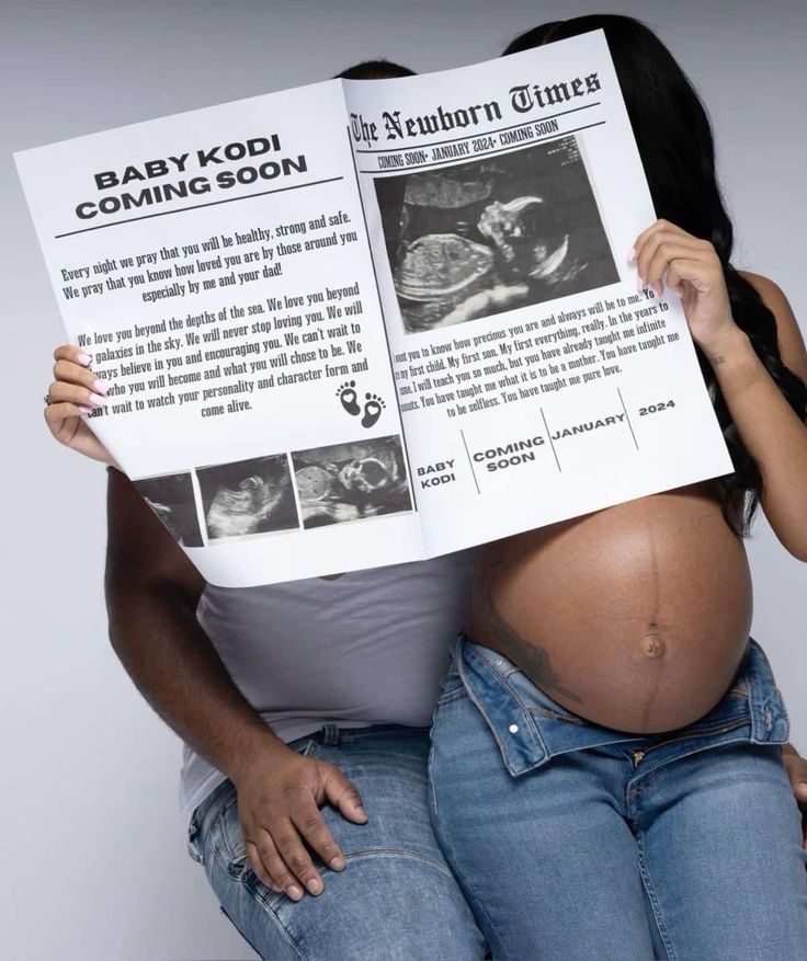 a pregnant woman is holding up a newspaper