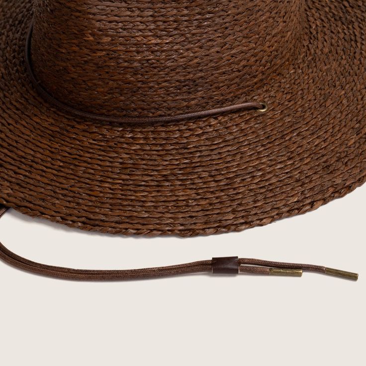 Our much loved, best selling Austin is back with an updated straw weave! From the desert to the sea, Austin Brown is hand braided from natural raffia straw. Designed to get you from dusty roads to salty seas and everywhere in between. The wide brim ensures sun protection and the chin strap will keep your hat on your head for every adventure. Summer Brown Toquilla Straw Hat Bands, Summer Hat Bands In Brown Toquilla Straw, Summer Brown Panama Hat With Palm Leaf, Summer Brown Panama Hat In Palm Leaf, Brown Palm Leaf Panama Hat For Vacation, Brown Flat Brim Panama Hat In Paper Straw, Western Style Palm Leaf Straw Hat For Beach, Bohemian Braided Palm Leaf Sun Hat, Rustic Brown Fedora For Beach