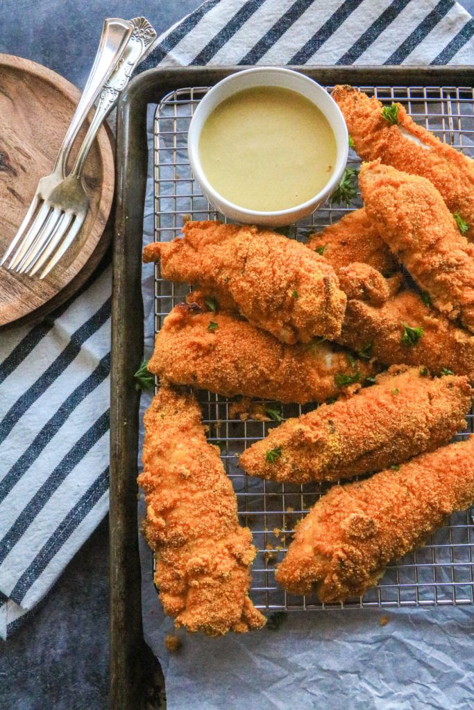 fried chicken sticks on a cooling rack with dipping sauce