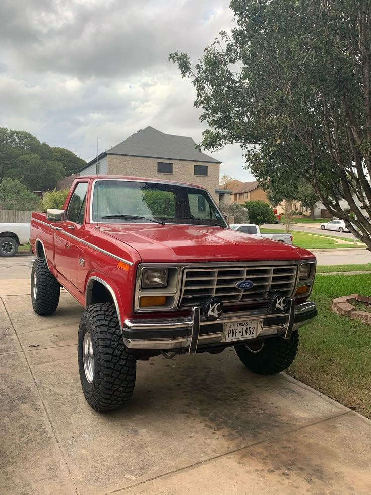 a red pick up truck parked in front of a house