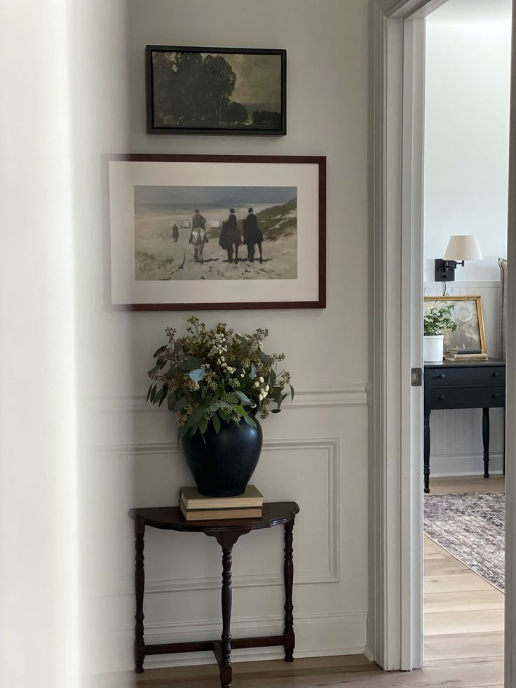 a vase with flowers sitting on top of a table in front of a doorway to another room