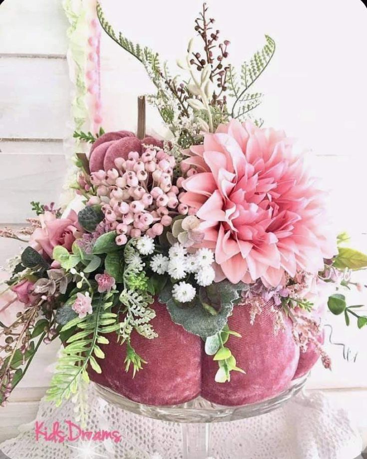 a vase filled with pink flowers and greenery