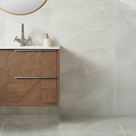 a bathroom with a sink, mirror and tile flooring in white colors on the walls