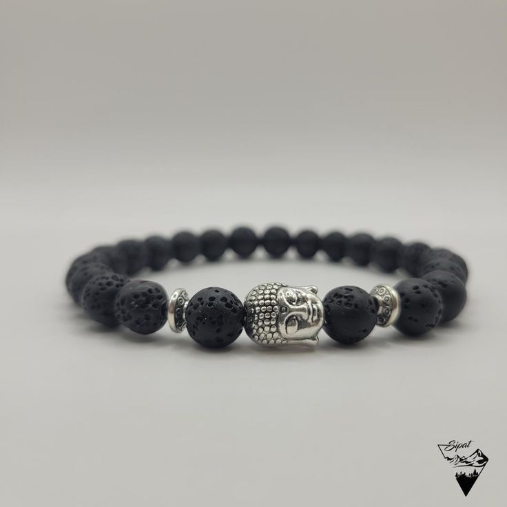 Bring a touch of serenity and sophistication to your outfit.The 8mm Buddha Head Lava Bead Bracelet is the versatile accessory you need. This handcrafted bracelet is custom made to fit your wrist perfectly. The number of beads varies depending on the size requested (approx. 25 beads for an 18cm wrist) The Buddha Head Lava Bead Bracelet is an elegant and spiritual accessory that will bring a touch of serenity and sophistication to your outfit. The black beads, made of lava stone, are recognizable by their porous and rough texture, adding a natural dimension to the bracelet. The small silver or gold metal Buddha head is finely detailed, adding a spiritual dimension to the bracelet. It will be placed between two small pearls matching the color of the Buddha's head (Silver or gold). The overall Hand-strung Lava Stone Bracelets, Adjustable 8mm Lava Stone Beaded Bracelets, Casual Bracelets For Meditation With 8mm Beads, Casual Bracelets With 8mm Beads For Meditation, Casual 8mm Beaded Bracelets For Meditation, Spiritual Lava Stone Bracelets With 8mm Beads, Minimalist Hand-strung Beaded Bracelets For Meditation, Elegant Stretch Bracelet With 8mm Beads For Meditation, Elegant 8mm Beads Stretch Bracelet For Meditation