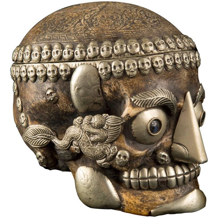 a bronze colored skull with an intricately decorated head