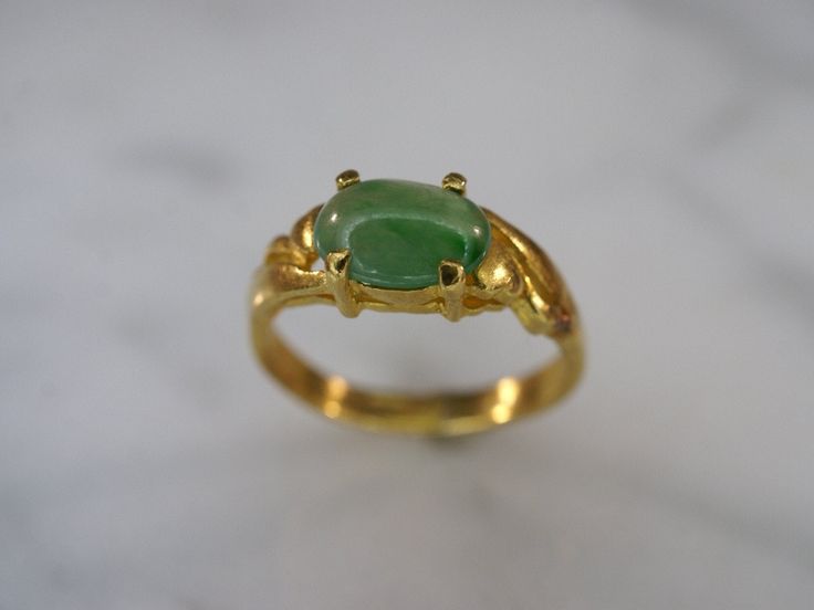 22k yellow gold and green jade ring is a size 4 1/2. An 8mm x 6mm oval jade cabochon is set in a four prong gallery setting with a high polish finish. Band tapers from 5mm at top to 3mm at bottom. No stamp. Green Jade Ring, Oxidized Brass, Gold And Green, Jade Ring, Green Jade, Photo Bracelet, Jade Green, Flower Shape, Cut Glass