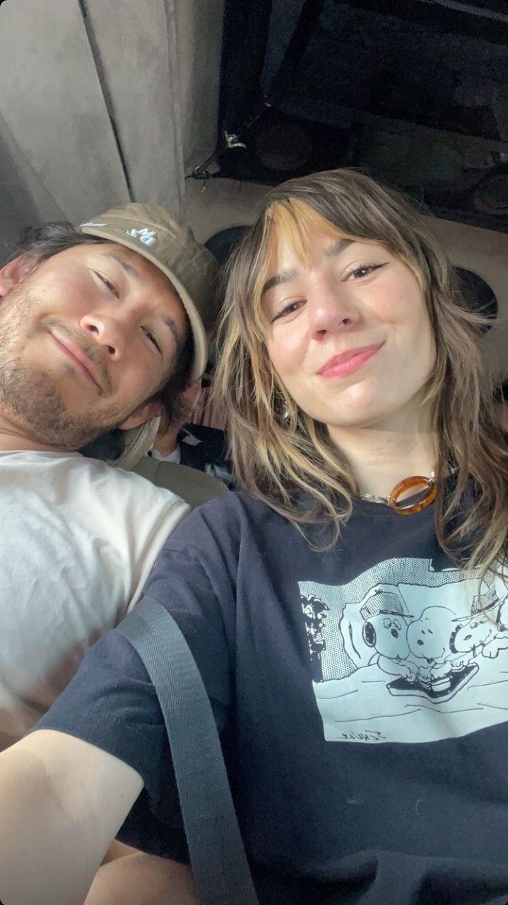 a man and woman laying down next to each other in the back of a car