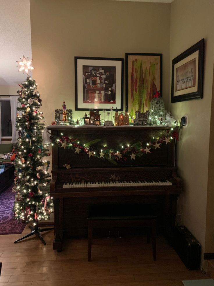 a living room with a piano and christmas lights on the tree in front of it