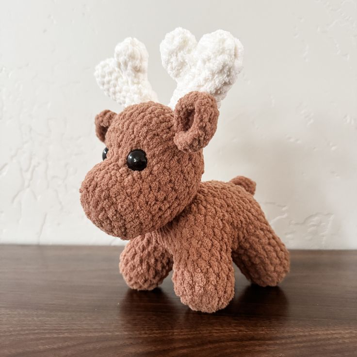 a crocheted stuffed animal sitting on top of a wooden table