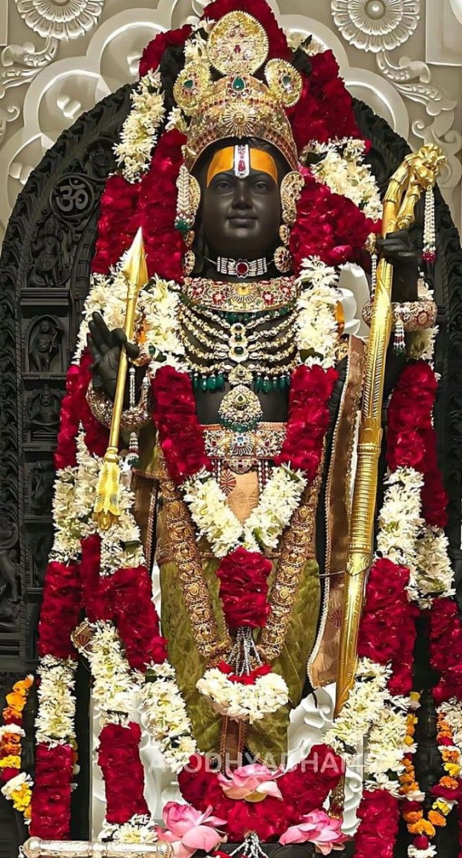 the statue is surrounded by red and white flowers