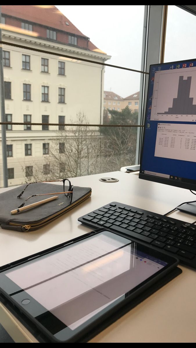 a tablet computer sitting on top of a desk next to a keyboard and monitor screen