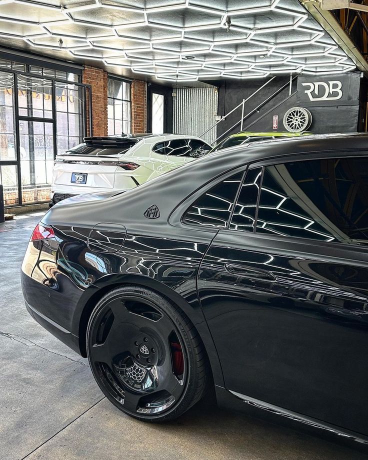 a black car parked in a garage next to other cars