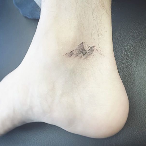 a foot with a mountain tattoo on it