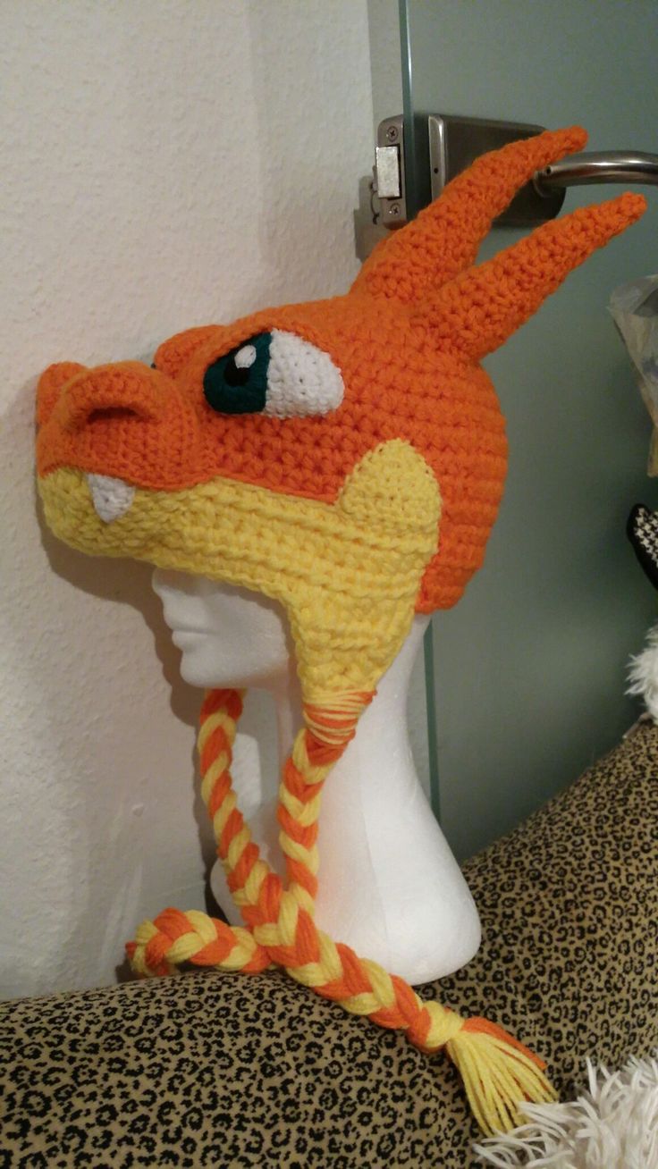 a crocheted orange and yellow hat on top of a white mannequin head