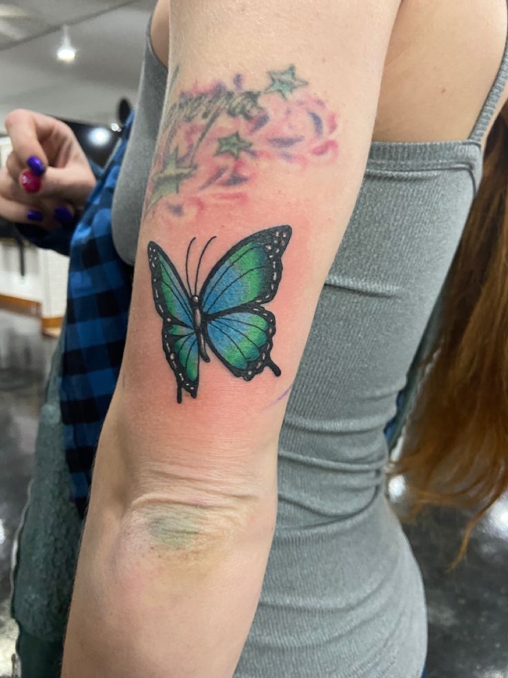 a woman with a butterfly tattoo on her arm