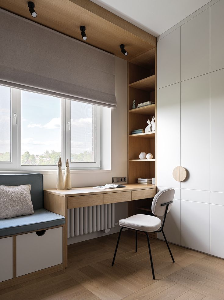 a room with a chair, desk and shelves in it next to a large window