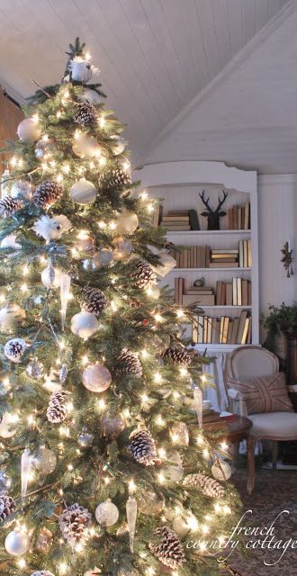 a christmas tree is decorated with white and silver ornaments