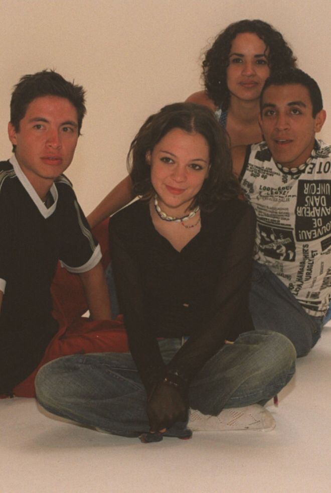 four people sitting on the floor posing for a photo