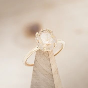 a diamond ring sitting on top of a piece of wood