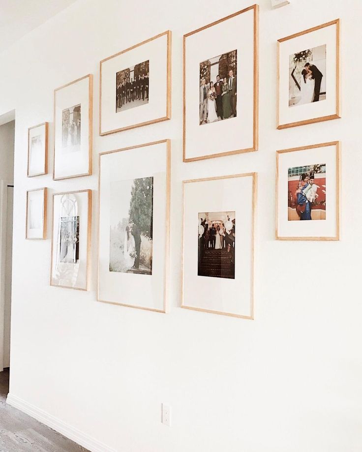 a white wall with many pictures hanging on it's side and a door in the background