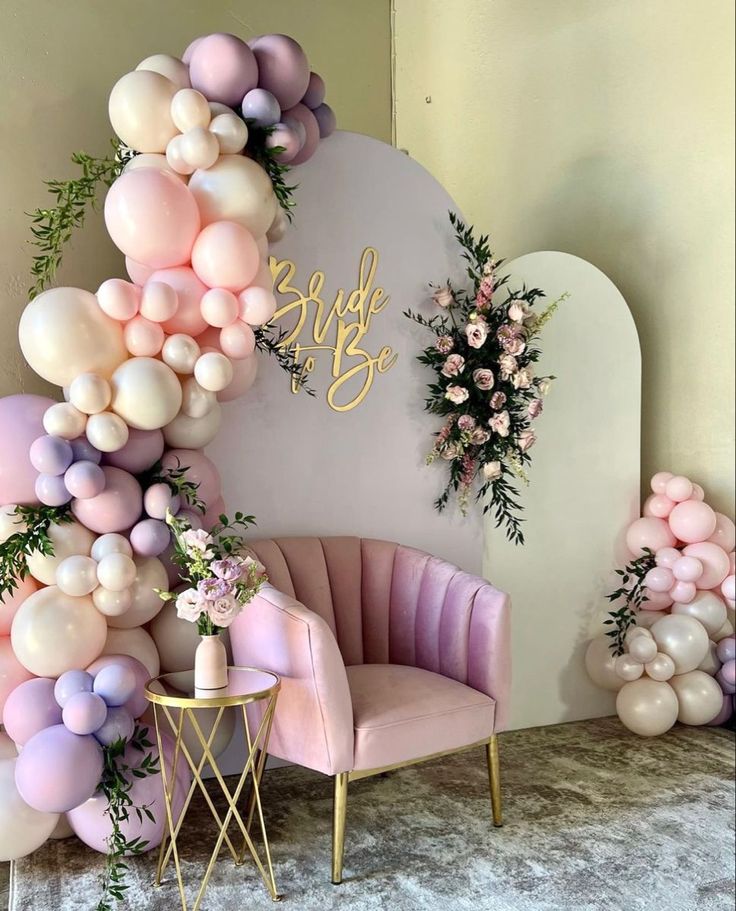 the balloon arch is decorated with flowers and greenery