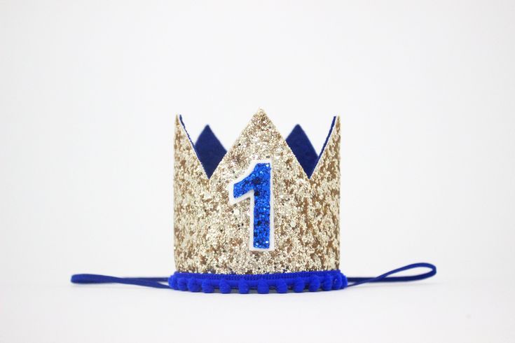 a blue and gold crown with the number one on it's side, sitting in front of a white background