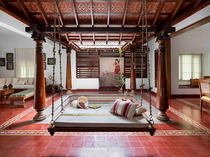 a living room with red tile flooring and wooden furniture in the middle of it