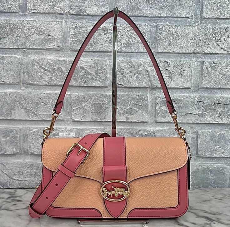 Brand new with the tag Authentic Color is Gold/Faded Blush/Taffy Refined pebble leather and smooth leather Inside zip pocket Snap closure, fabric lining Detachable handle with 9" drop Outside open pocket Detachable strap with 22" drop for shoulder or crossbody wear 10 3/4" (L) x 5 1/2" (H) x 2 3/4" (W) Same or next day shipping! Coach Georgie, Taffy, Pebbled Leather, Smooth Leather, Purses And Handbags, Snap Closure, Color Blocking, Shoulder Bags, Zip Pockets