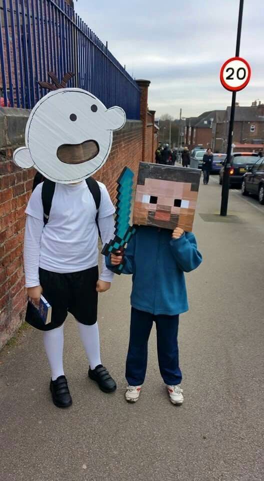 two children in costumes standing on the street with their faces painted like an animal and one has a cardboard box attached to his head