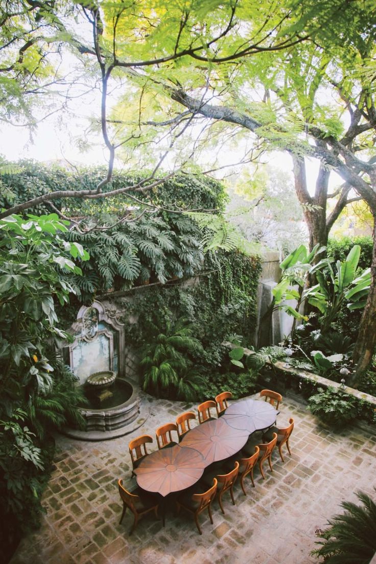 an outdoor dining table surrounded by greenery