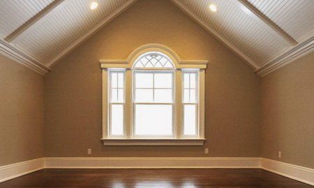 an empty room with wood floors and a large window