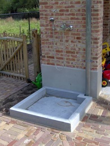 an outdoor shower in the middle of a brick patio